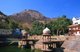 India: The walled fortifications of the Bala Qila (Alwar Fort) loom above the huge kund (tank) next to the Vinay Vilas (City Palace), Alwar, Rajasthan